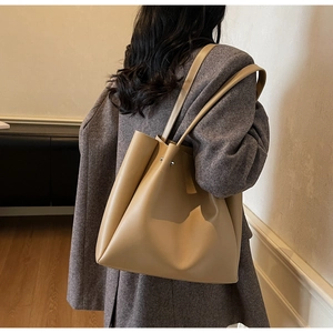 Detailed view of khaki large tote bag showing leather texture and slim shoulder straps