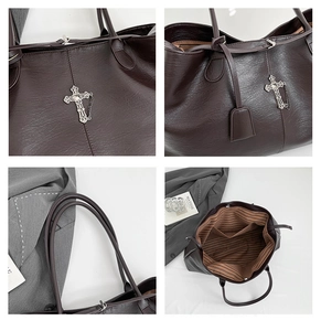 Dettaglio borsa shopper marrone con ciondolo a croce, texture martellata e fodera a righe