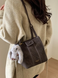 Retro dark brown matte bucket bag for women featuring white contrast stitching and bunny charm