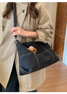 Detalle del bolso tote retro de gamuza con costuras en contraste y ojetes de plata