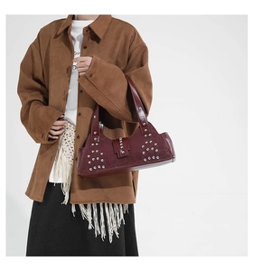 Detail view of burgundy leather underarm bag with silver rivets and vintage buckle design