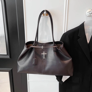 Dettaglio della borsa tote gotica vintage marrone scuro con croce in metallo e nappe