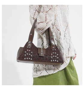 Close-up of leopard print underarm bag featuring silver studs and punk style texture