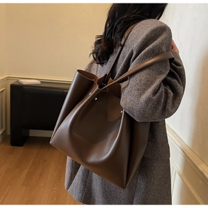 Detail showing the brown large-capacity tote bag with high-quality leather texture