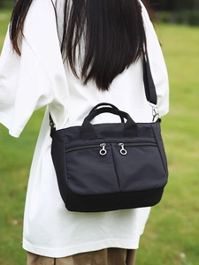 Minimalist black nylon crossbody tote bag with multi-pocket design for daily commute
