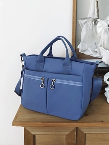 Blue nylon tote bag with double front zip pockets and adjustable shoulder strap