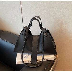 Close-up of black lychee grain texture and trapezoid structure of the leather tote bag