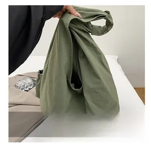 Close-up of lightweight army green nylon tote bag showing textured fabric and large capacity