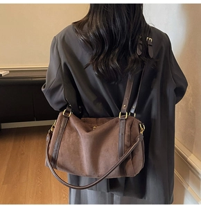Détail d'un grand sac fourre-tout en daim marron porté par un mannequin dans une pièce