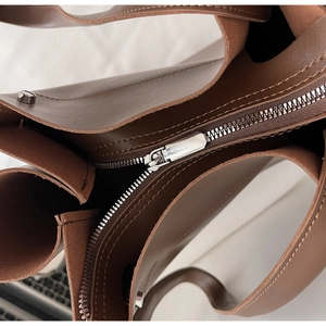 Detail of silver metal zipper and dark brown lining on a minimalist tote bag