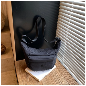 Detail der dunkelgrauen Beuteltasche mit Nylonstruktur, Reißverschlüssen und Gurt
