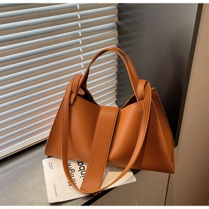 Detailed macro shot of caramel brown lychee grain leather on a vintage crossbody bag