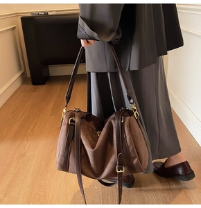 Détail d'un grand sac fourre-tout en daim marron foncé avec des textures rétro élégantes