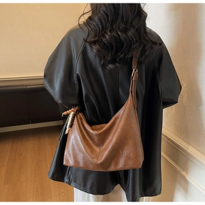 Détail du grand sac hobo marron avec accessoire de perles ethniques sur mannequin