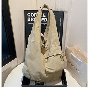 Macro detail of khaki nylon hobo bag featuring knotted shoulder strap and side cargo pocket
