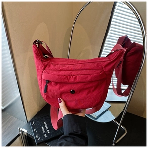 Nahaufnahme der roten Nylon-Sichelstasche mit Reißverschlussdetails und verstellbarem Gurt