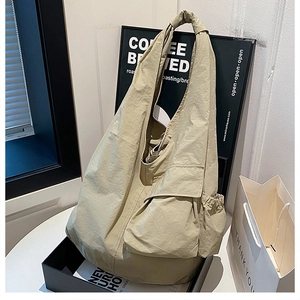 Close-up of light khaki large tote bag with functional flap pockets and side drawstring