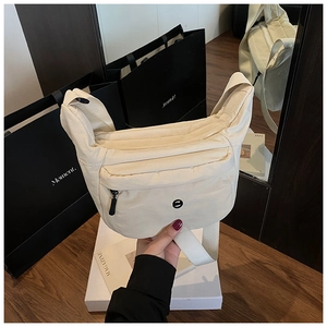 Detailansicht der cremefarbenen Nylon-Halbmondtasche mit Gurt und Reißverschlussfach