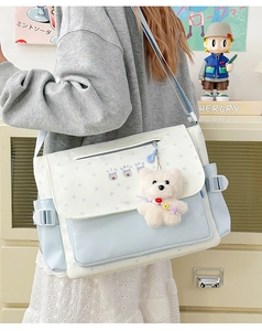 Détail du motif d'étoile et pendentif ours en peluche sur sac fourre-tout bleu