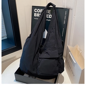 Detailed view of a black high-capacity techwear crossbody bag with multi-pocket design