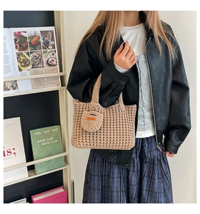 Detail of hand-woven beige knit handbag with a matching mini round coin purse charm
