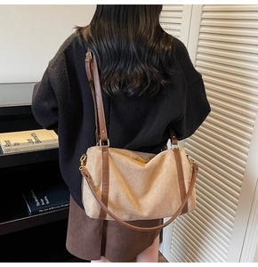 Détail d'un grand sac bandoulière en daim beige avec lanières en cuir marron et métal doré