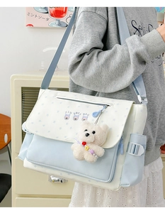 Détail du sac cabas bleu clair et beige avec motifs d'étoiles et porte-clés ours