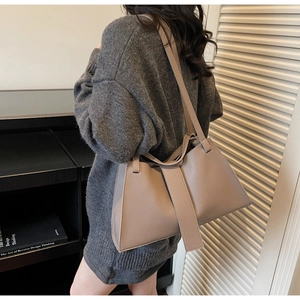 Lifestyle view of a textured khaki leather hobo bag worn on shoulder for daily commute