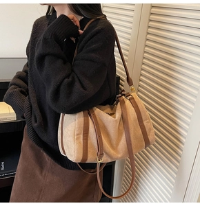 Détail du sac à bandoulière en suède avec garniture en cuir brun porté par un modèle
