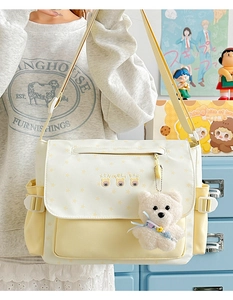 Détail du sac à bandoulière crème et jaune avec imprimés ours et pendentif en peluche