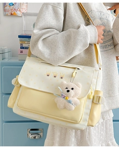 Détail du sac messager à motif d'étoiles avec pendentif ours en peluche et sangle