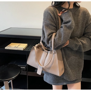 Detail of beige lychee pattern leather shoulder bag with spacious trapezoid design