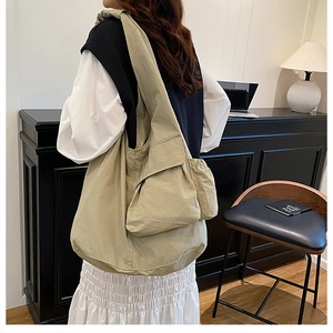 Detail of khaki canvas tote bag with functional drawstring side pockets and large capacity
