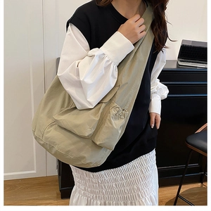 Detail of khaki large capacity tote bag featuring side drawstring and functional pockets