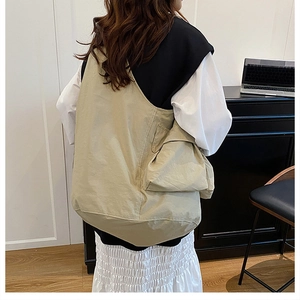 Detailed view of khaki large capacity tote bag worn over the shoulder for daily use