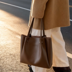Large dark coffee leather tote bag with side pleats and silver rivets for commuting