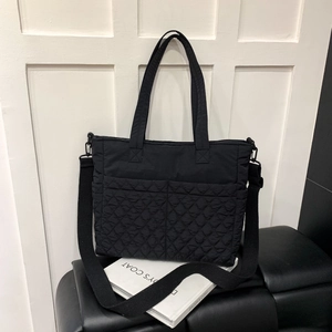 Détail du sac cabas matelassé noir avec grande capacité et bandoulière large réglable