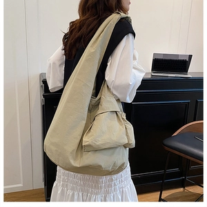 Macro view of lightweight khaki tote bag featuring side drawstring pockets and large capacity