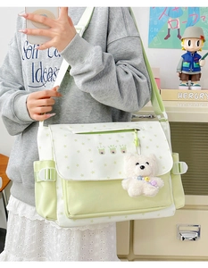 Détail du sac bandoulière vert à motif d'étoiles avec un pendentif ours en peluche blanc