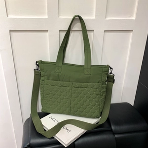 Vue détaillée du sac cabas matelassé vert foncé avec larges bandoulières et poches