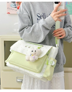 Détail du sac bandoulière vert à motif d'étoiles avec un pendentif ours en peluche