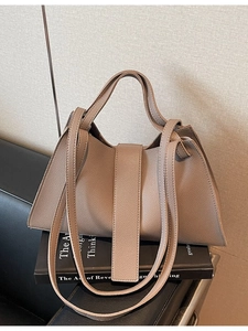 Minimalist taupe lychee leather tote bag with dual handles and long shoulder strap