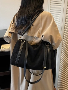 Grand sac cabas en suédine noire porté sur un trench-coat pour un look décontracté