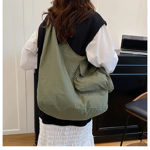 Detail view of large olive green hobo bag featuring a functional front flap pocket