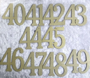 Golden glitter numbered stencils from 40 to 49 with hanging holes on white plush surface