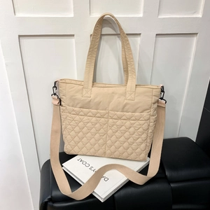 Vue détaillée d'un sac cabas matelassé beige montrant la texture et la bandoulière