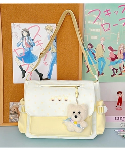 Détail du sac bandoulière jaune avec motifs d'étoiles et porte-clé ours blanc mignon