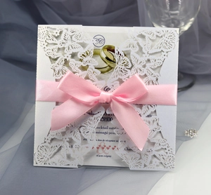 Details einer lasergeschnittenen Schmetterlings-Hochzeitseinladung mit rosa Schleife