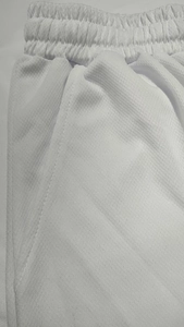 Detalle de tejido de malla transpirable blanco y cintura elástica en pantalones cortos