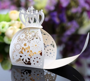 Close-up of elegant laser-cut floral favor box with a gold chocolate inside